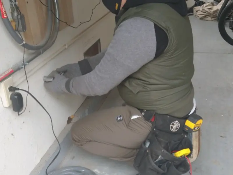 Electrician performing outlet wiring in a Buckhall garage